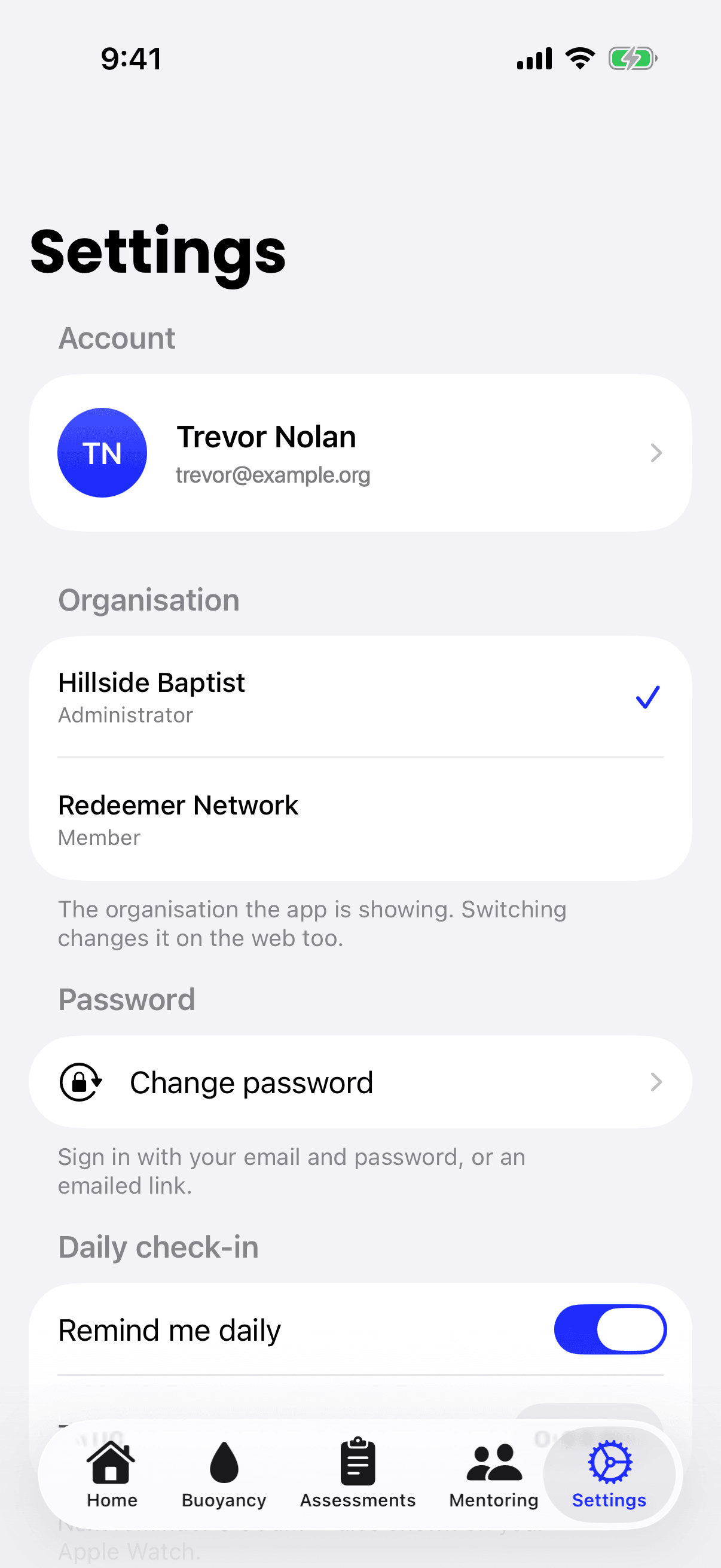 The iPhone Settings screen, with an Organisation section listing 2 organisations and the person's role in each, and a tick beside the one the app is showing.